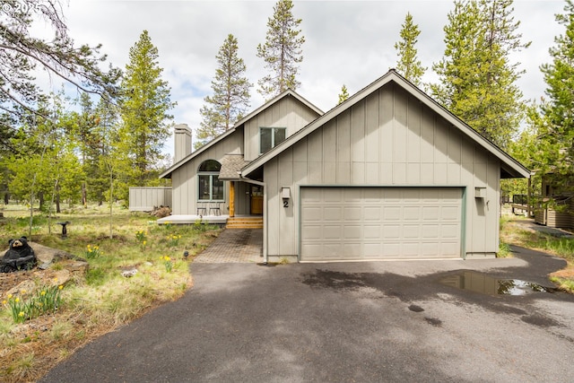 17692 Rogue Ln, Sunriver, OR 97707 - view of front facade with a chimney, a garage, and driveway