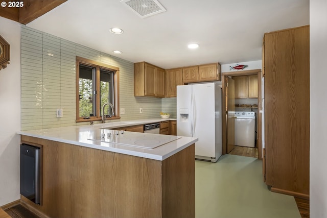 17692 Rogue Ln, Sunriver, OR 97707 - kitchen with white appliances, washer / clothes dryer, a peninsula, light countertops, and a sink