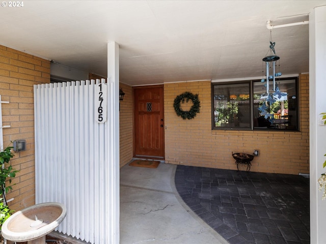 view of exterior entry featuring brick siding