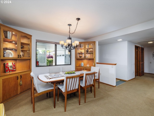 dining room with baseboards, a chandelier, and light carpet