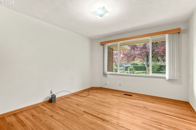 empty room featuring wood finished floors and baseboards