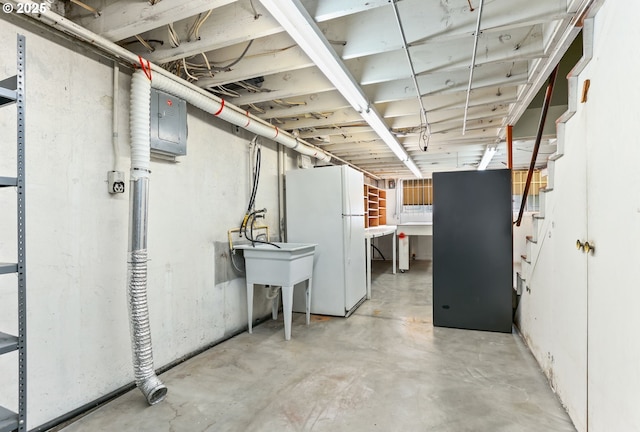 unfinished below grade area featuring freestanding refrigerator and electric panel