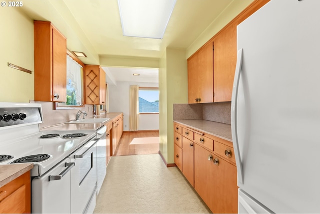 kitchen with white appliances, a sink, tasteful backsplash, and light countertops