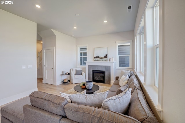 17955 SW Howlock Ln, Beaverton, OR 97007 - living area with recessed lighting, a tiled fireplace, light wood finished floors, baseboards, and plenty of natural light