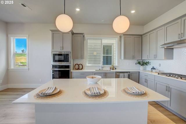 17955 SW Howlock Ln, Beaverton, OR 97007 - kitchen featuring gray cabinets, appliances with stainless steel finishes, under cabinet range hood, a sink, and recessed lighting