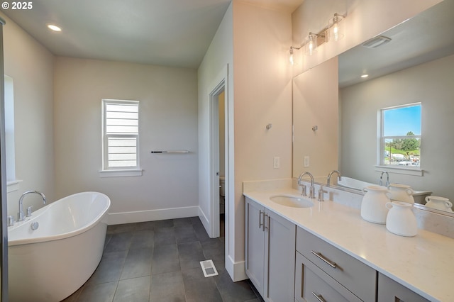 17955 SW Howlock Ln, Beaverton, OR 97007 - bathroom featuring vanity, tile patterned flooring, baseboards, a freestanding bath, and recessed lighting