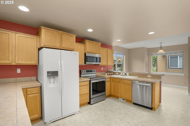 1544 SW 175th Ave, Beaverton, OR 97003 - kitchen featuring stainless steel appliances, a peninsula, a sink, tile countertops, and recessed lighting
