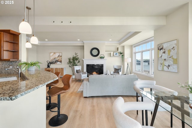 707 N Hayden Island Dr Unit 415, Portland, OR 97217 - living area with light wood finished floors, a glass covered fireplace, a tray ceiling, ornamental molding, and recessed lighting