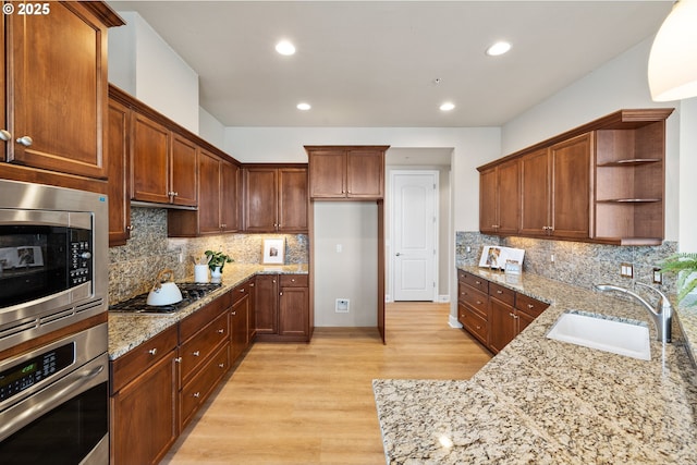707 N Hayden Island Dr Unit 415, Portland, OR 97217 - kitchen with open shelves, appliances with stainless steel finishes, light wood-style floors, light stone countertops, and tasteful backsplash