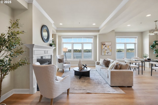 707 N Hayden Island Dr Unit 415, Portland, OR 97217 - living area with crown molding, wood finished floors, a fireplace, recessed lighting, and a water view