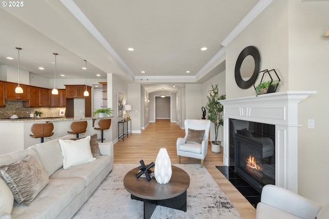 707 N Hayden Island Dr Unit 415, Portland, OR 97217 - living area with recessed lighting, light wood finished floors, a fireplace with flush hearth, crown molding, and a raised ceiling