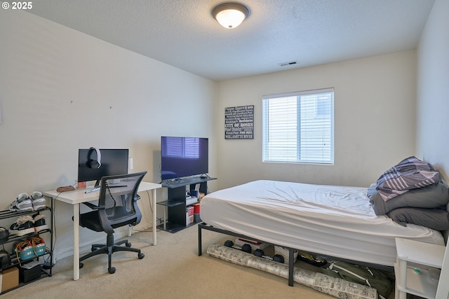 carpeted bedroom with visible vents and a textured ceiling