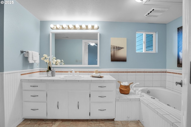 3270 N Maple St, Canby, OR 97013 - bathroom featuring vanity, marble finish flooring, a tub with jets, and wainscoting