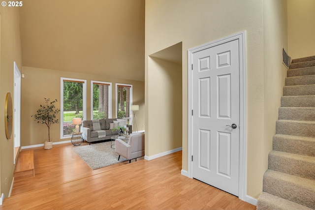 3270 N Maple St, Canby, OR 97013 - living room with a towering ceiling, stairway, light wood-style flooring, and baseboards
