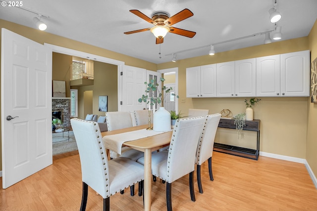 3270 N Maple St, Canby, OR 97013 - dining area featuring track lighting, a ceiling fan, a fireplace, and light wood-style flooring