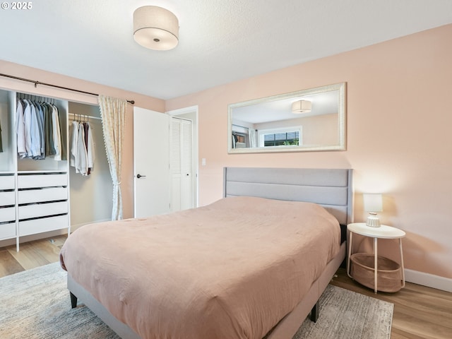 bedroom with baseboards and wood finished floors