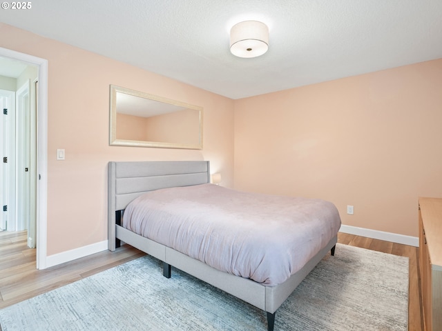 bedroom with baseboards and wood finished floors