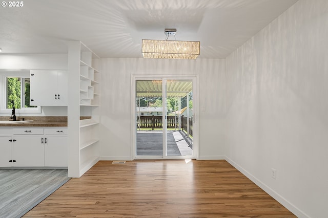 116 SE 153rd Ave, Portland, OR 97233 - unfurnished dining area featuring light wood-style floors, a sink, and baseboards