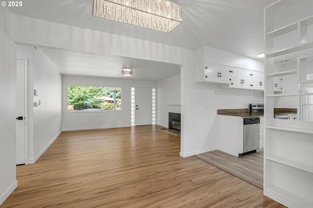 116 SE 153rd Ave, Portland, OR 97233 - unfurnished living room featuring a fireplace, light wood-style floors, baseboards, and a chandelier