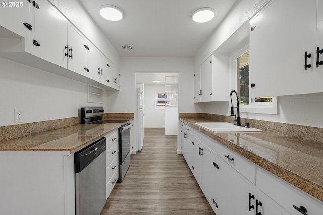 116 SE 153rd Ave, Portland, OR 97233 - kitchen featuring appliances with stainless steel finishes, a sink, white cabinetry, and light wood-style flooring