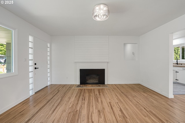 116 SE 153rd Ave, Portland, OR 97233 - unfurnished living room featuring light wood finished floors, baseboards, and a fireplace