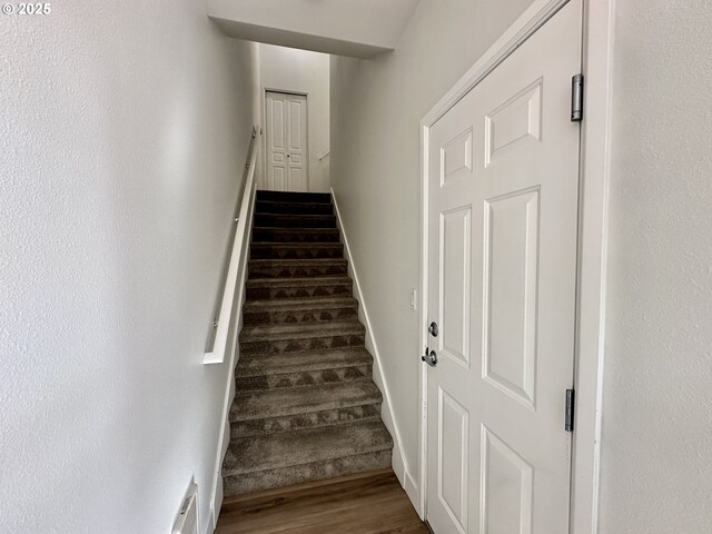 stairs with visible vents and wood finished floors