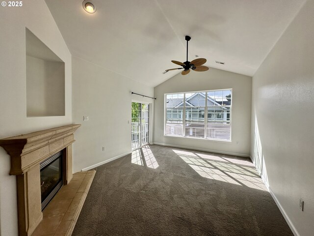 unfurnished living room with ceiling fan, vaulted ceiling, baseboards, a glass covered fireplace, and carpet