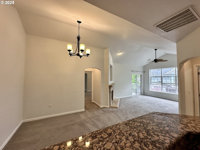 interior space with carpet floors, arched walkways, ceiling fan with notable chandelier, vaulted ceiling, and visible vents