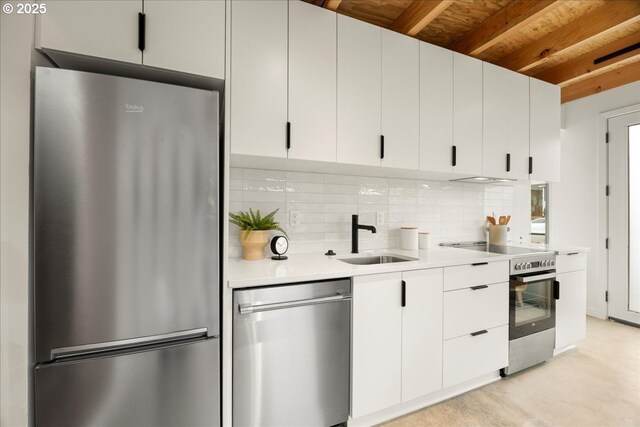 kitchen featuring decorative backsplash, beamed ceiling, light countertops, a sink, and appliances with stainless steel finishes