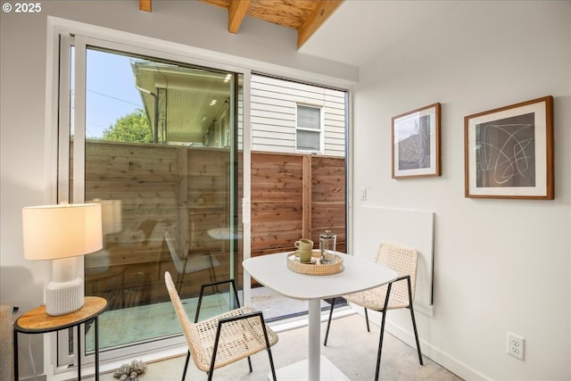 dining room with baseboards and beam ceiling