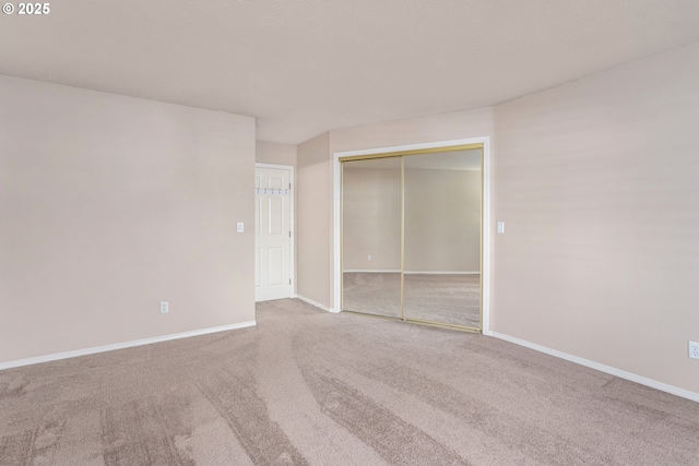 unfurnished bedroom with a closet, carpet, and baseboards