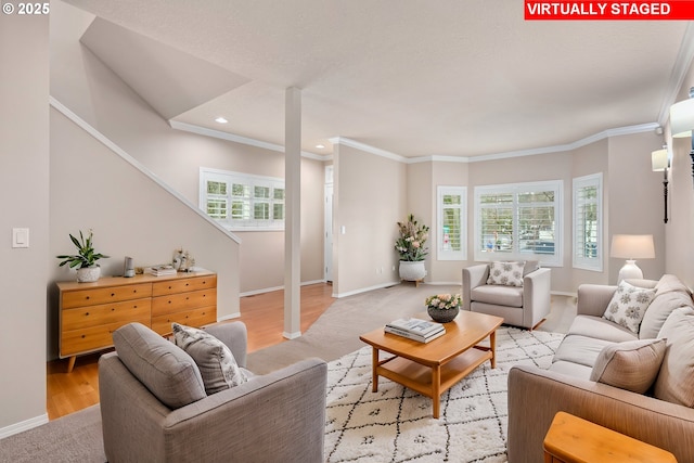 living room with light wood-type flooring, baseboards, and crown molding