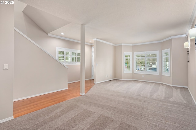 unfurnished living room featuring carpet floors, ornamental molding, and baseboards