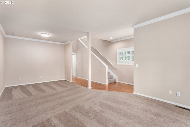 interior space with light colored carpet, visible vents, baseboards, stairs, and crown molding