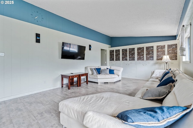 living room featuring vaulted ceiling, a textured ceiling, and wood finished floors