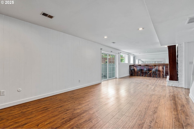 unfurnished living room featuring wood finished floors, baseboards, and recessed lighting
