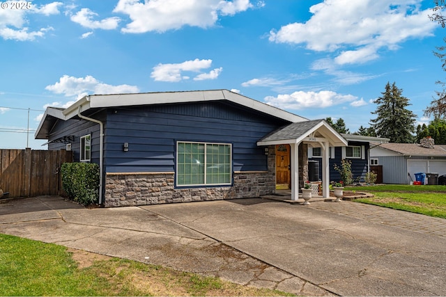 view of front of home featuring stone siding and fence