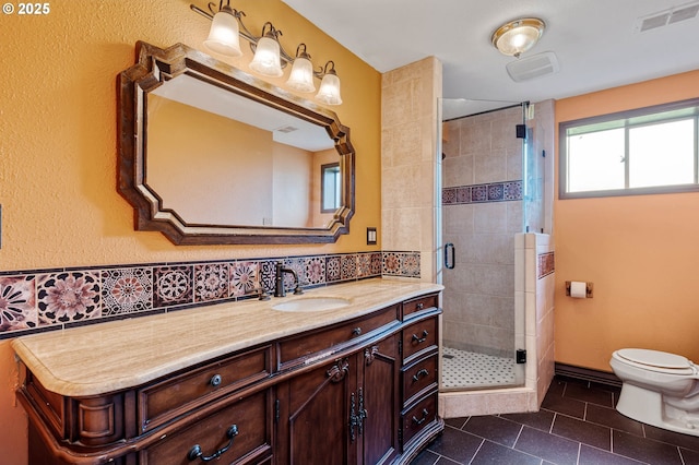 bathroom featuring tile patterned floors, toilet, a stall shower, and vanity