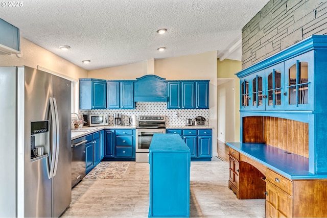 kitchen with stainless steel appliances, blue cabinets, a sink, a textured ceiling, and backsplash