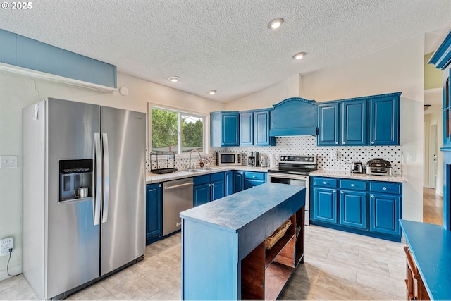 kitchen featuring stainless steel appliances, blue cabinetry, a sink, decorative backsplash, and light countertops