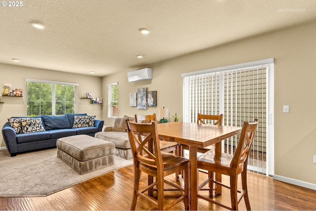 21889 SW Cedar Brook Way, Sherwood, OR 97140 - dining room with a wall mounted AC, wood finished floors, recessed lighting, and a textured ceiling