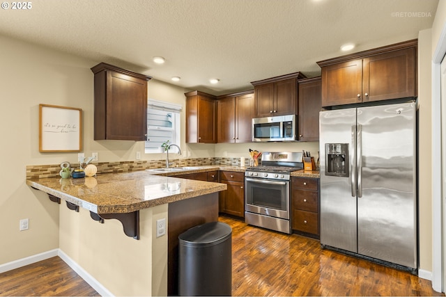 21889 SW Cedar Brook Way, Sherwood, OR 97140 - kitchen featuring stainless steel appliances, a peninsula, tile counters, recessed lighting, and dark wood-type flooring