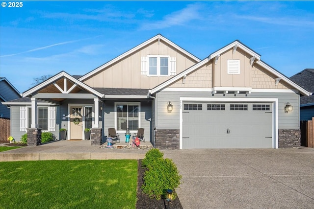 craftsman house with driveway, board and batten siding, stone siding, an attached garage, and a front lawn