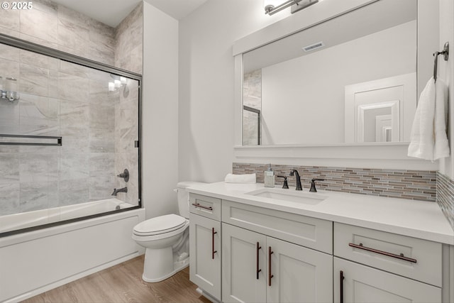 7705 NE 181st Ct, Vancouver, WA 98682 - bathroom featuring vanity, toilet, tasteful backsplash, wood finished floors, and combined bath / shower with glass door