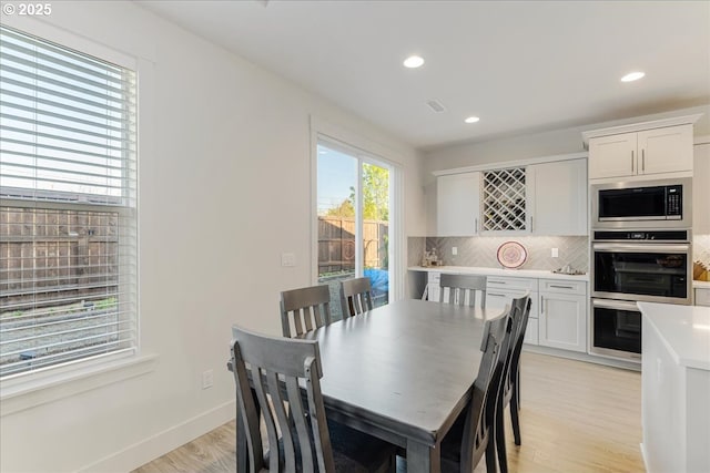 dining room with light wood-type flooring, baseboards, recessed lighting, and visible vents