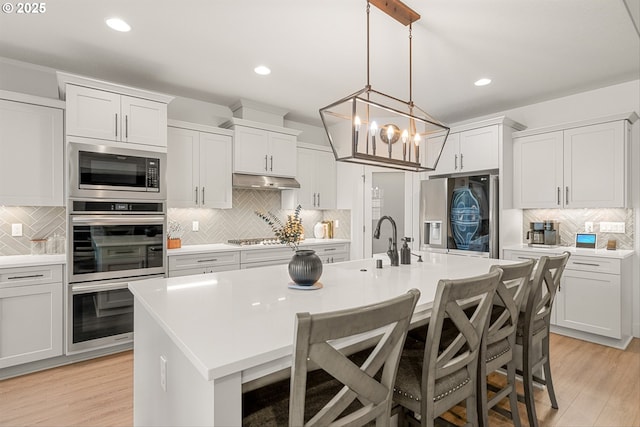 7705 NE 181st Ct, Vancouver, WA 98682 - kitchen with stainless steel appliances, tasteful backsplash, light countertops, a kitchen island with sink, and recessed lighting