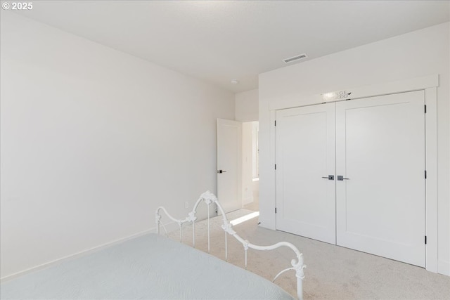 bedroom featuring carpet floors, visible vents, and a closet