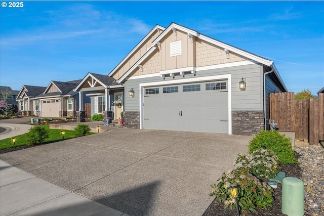 craftsman-style home with driveway, stone siding, board and batten siding, fence, and a garage