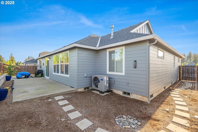 back of property with a shingled roof, a fenced backyard, ac unit, and a patio