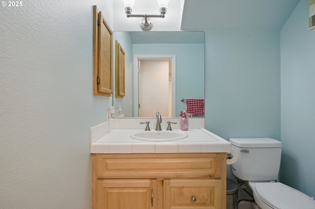 bathroom featuring toilet and vanity
